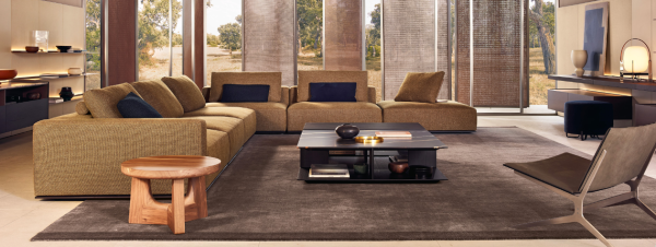 The Westside Sofa by Poliform has a commanding presence, with a wide, sturdy base that anchors it firmly to the ground . It is featured in a natural colour with contrasting tones in a contemporary living room.